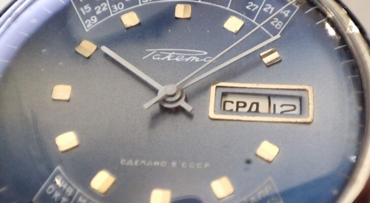 Orologi Russi e Sovietici Autentici – Vostok, Poljot, Raketa 13 Orologio russo Raketa vintage con giorno e data in cirillico. Quadrante blu con indici dorati e movimento meccanico manuale. Prodotto in Unione Sovietica (CCCP)