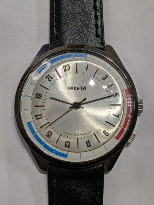 Orologio Raketa 24h Polar transizionale, quadrante argentato con scala 24 ore, ghiera interna girevole, cinturino generico nero.