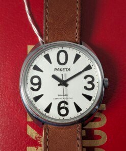 Orologio da polso Raketa Big Zero russo con quadrante bianco, numeri arabi neri (0, 3, 6, 9), lancette nere e cinturino in pelle marrone originale, presentato con la sua scatola originale.