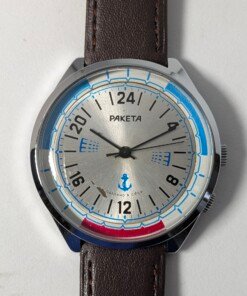 Orologio da polso sovietico Raketa Marine 24 ore vintage degli anni '80 con quadrante argentato, indicazione delle 24 ore, lunetta blu e rossa con simboli marittimi e cinturino in pelle marrone.