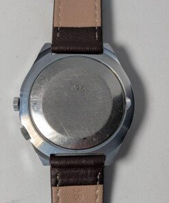 Raketa Marine 24 Ore Sovietico Vintage (Anni '80) Grade C 13 Orologio da polso sovietico Raketa Marine 24 ore vintage degli anni '80 con quadrante argentato, indicazione delle 24 ore, lunetta blu e rossa con simboli marittimi e cinturino in pelle marrone.