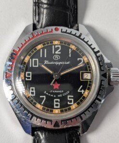 Vostok Komandirskie Zakaz MO CCCP meccanico manuale 2414 - Grade B 8 Orologio da polso militare sovietico Vostok Komandirskie Zakaz MO CCCP a carica manuale (calibro 2414) con quadrante nero, numeri arabi bianchi, lancette luminose, ghiera girevole e cinturino in pelle nera.