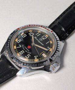 Vostok Komandirskie Zakaz MO CCCP meccanico manuale 2414 - Grade B 12 Orologio da polso militare sovietico Vostok Komandirskie Zakaz MO CCCP a carica manuale (calibro 2414) con quadrante nero, numeri arabi bianchi, lancette luminose, ghiera girevole e cinturino in pelle nera.