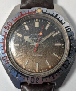 Orologio subacqueo sovietico vintage Vostok Amphibia 470 degli anni '80 con quadrante scuro, indici luminosi, ghiera girevole numerata e cinturino in pelle marrone.