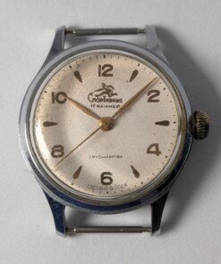 Sportivnie "Running Man" Sovietico Anni '50 Hacking Second Calibro 2634 (Ex 1MWF) - Grade B 14 Orologio da polso sovietico Sportivnie "Running Man" degli anni '50 con quadrante color crema, numeri arabi neri, lancette dorate, secondi centrali con funzione hacking e il logo dell'uomo che corre, alimentato dal calibro 2634 (ex 1MWF).