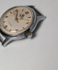 Sportivnie "Running Man" Sovietico Anni '50 Hacking Second Calibro 2634 (Ex 1MWF) - Grade B 24 Orologio da polso sovietico Sportivnie "Running Man" degli anni '50 con quadrante color crema, numeri arabi neri, lancette dorate, secondi centrali con funzione hacking e il logo dell'uomo che corre, alimentato dal calibro 2634 (ex 1MWF).