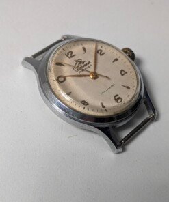 Sportivnie "Running Man" Sovietico Anni '50 Hacking Second Calibro 2634 (Ex 1MWF) - Grade B 23 Orologio da polso sovietico Sportivnie "Running Man" degli anni '50 con quadrante color crema, numeri arabi neri, lancette dorate, secondi centrali con funzione hacking e il logo dell'uomo che corre, alimentato dal calibro 2634 (ex 1MWF).