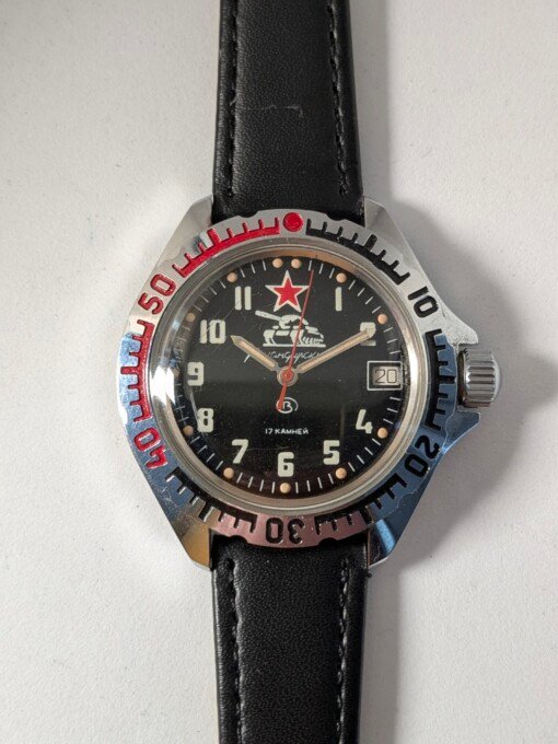Orologio Vostok Komandirskie con quadrante nero e disegno di carro armato, ghiera bicolore e cinturino nero