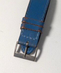 Orologio Sovietico Raketa Marine 24h con Cinturino Originale Blu - Grade B 27 Orologio sovietico Raketa Marine 24 ore anni '80 con quadrante argentato, linee blu tratteggiate per silenzio radio e cinturino blu