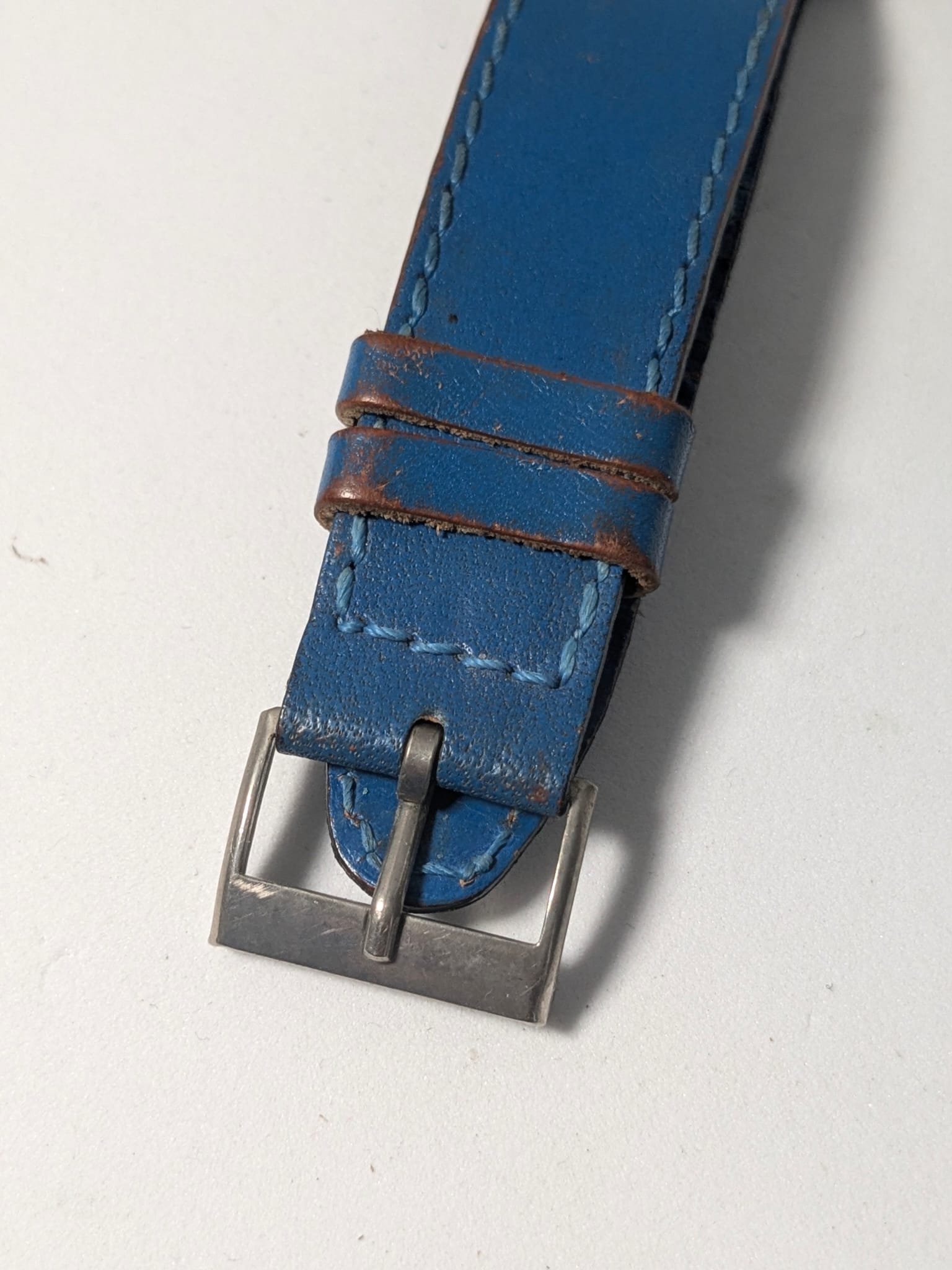 Orologio Sovietico Raketa Marine 24h con Cinturino Originale Blu - Grade B 14 Orologio sovietico Raketa Marine 24 ore anni '80 con quadrante argentato, linee blu tratteggiate per silenzio radio e cinturino blu