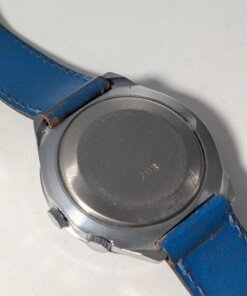 Orologio Sovietico Raketa Marine 24h con Cinturino Originale Blu - Grade B 25 Orologio sovietico Raketa Marine 24 ore anni '80 con quadrante argentato, linee blu tratteggiate per silenzio radio e cinturino blu