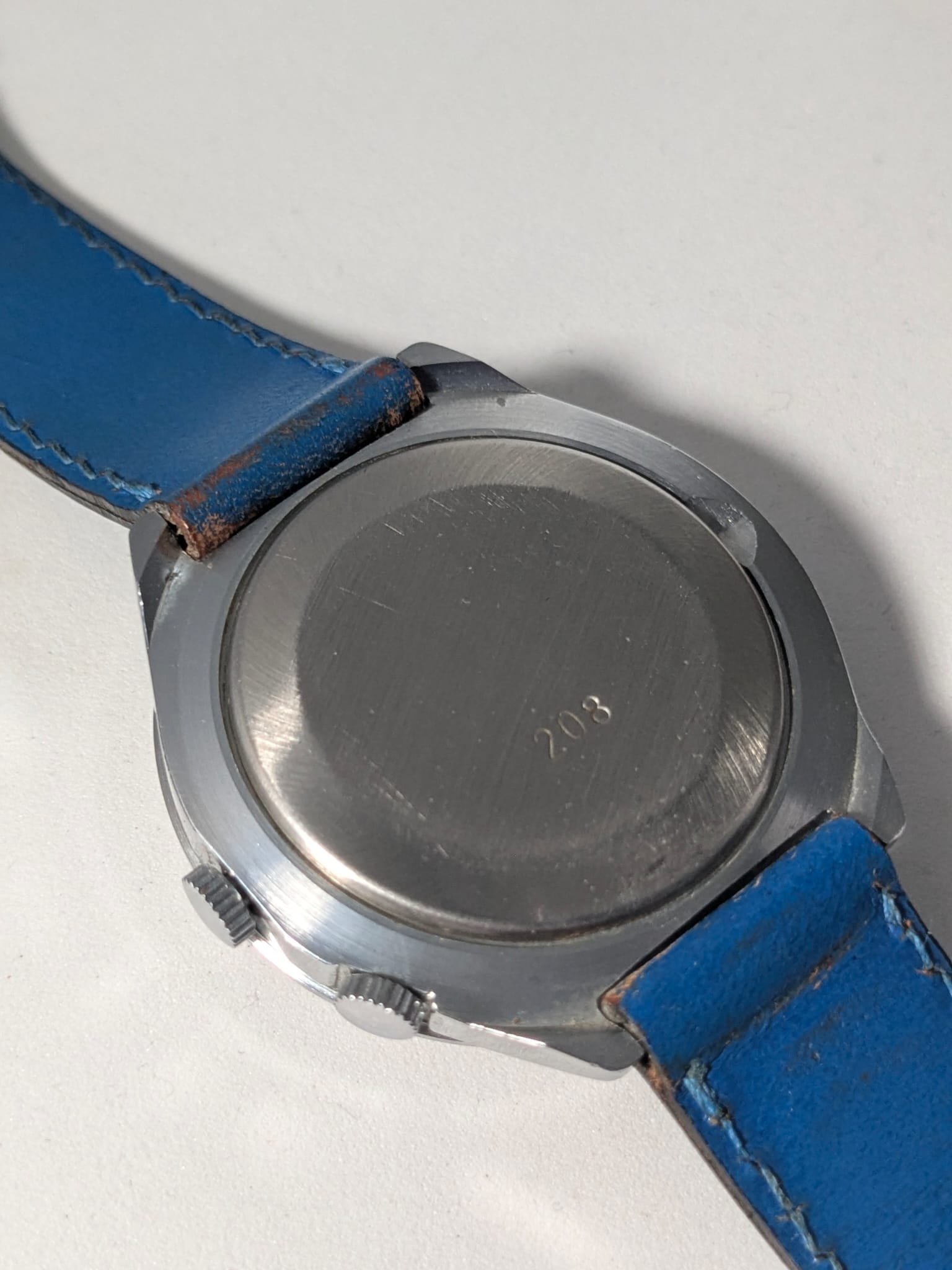 Orologio Sovietico Raketa Marine 24h con Cinturino Originale Blu - Grade B 12 Orologio sovietico Raketa Marine 24 ore anni '80 con quadrante argentato, linee blu tratteggiate per silenzio radio e cinturino blu