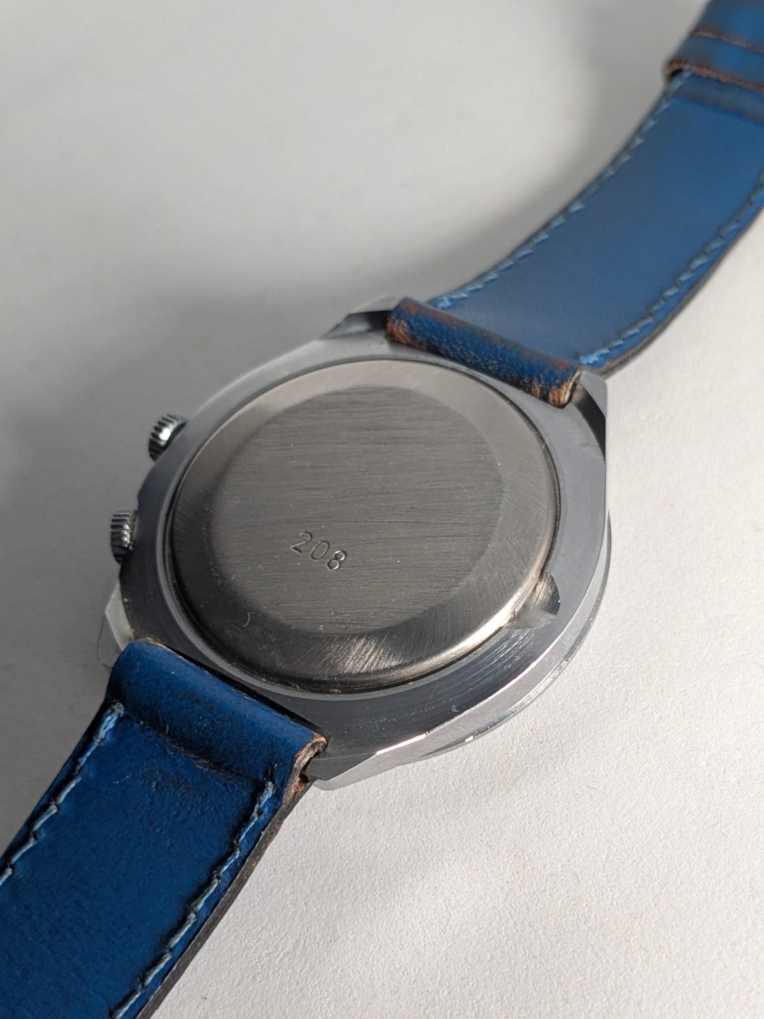 Orologio Sovietico Raketa Marine 24h con Cinturino Originale Blu - Grade B 7 Orologio sovietico Raketa Marine 24 ore anni '80 con quadrante argentato, linee blu tratteggiate per silenzio radio e cinturino blu