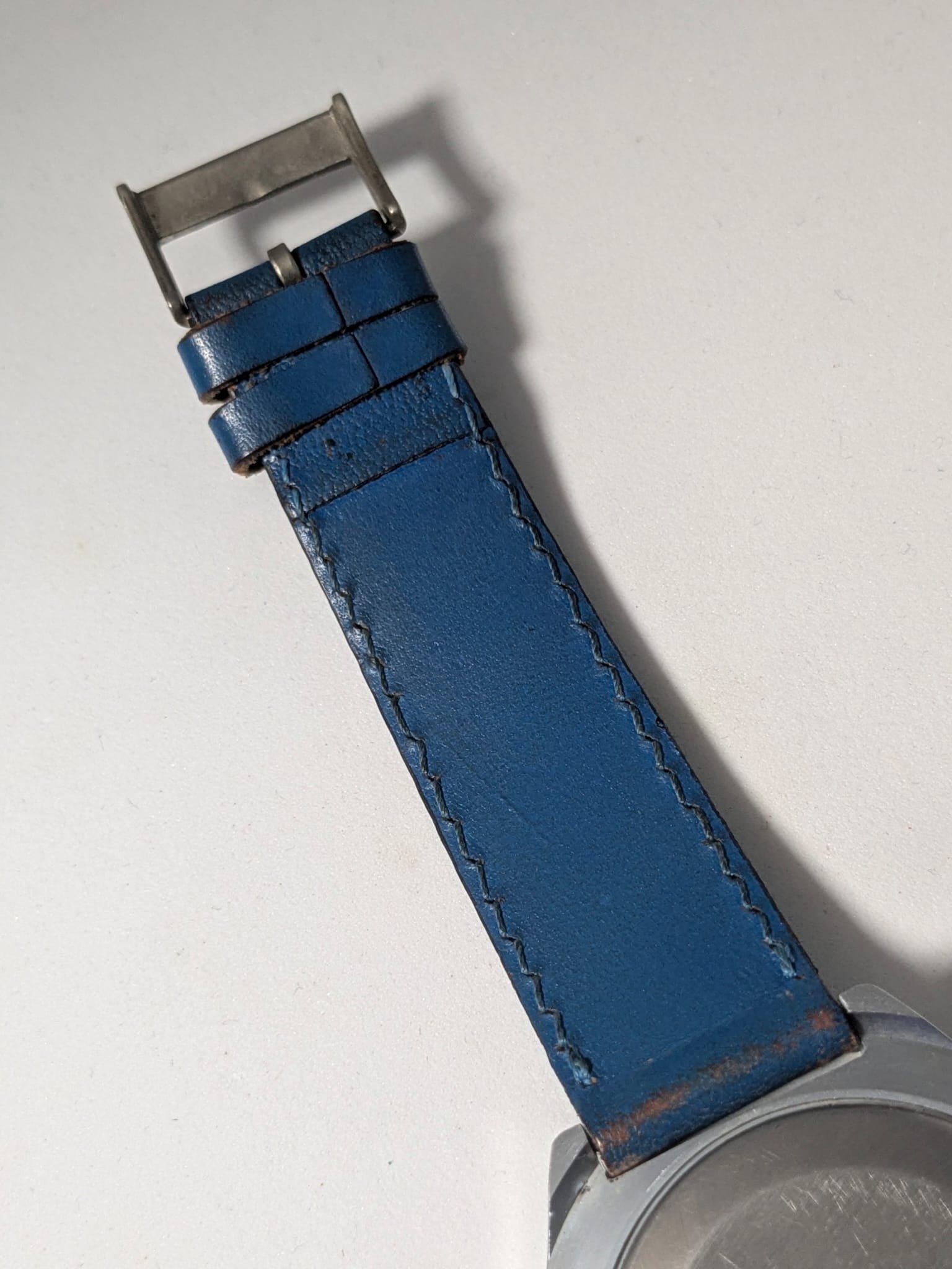 Orologio Sovietico Raketa Marine 24h con Cinturino Originale Blu - Grade B 13 Orologio sovietico Raketa Marine 24 ore anni '80 con quadrante argentato, linee blu tratteggiate per silenzio radio e cinturino blu
