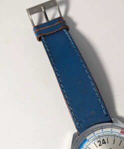 Orologio Sovietico Raketa Marine 24h con Cinturino Originale Blu - Grade B 16 Orologio sovietico Raketa Marine 24 ore anni '80 con quadrante argentato, linee blu tratteggiate per silenzio radio e cinturino blu