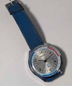 Orologio Sovietico Raketa Marine 24h con Cinturino Originale Blu - Grade B 22 Orologio sovietico Raketa Marine 24 ore anni '80 con quadrante argentato, linee blu tratteggiate per silenzio radio e cinturino blu