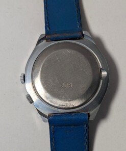 Orologio Sovietico Raketa Marine 24h con Cinturino Originale Blu - Grade B 21 Orologio sovietico Raketa Marine 24 ore anni '80 con quadrante argentato, linee blu tratteggiate per silenzio radio e cinturino blu
