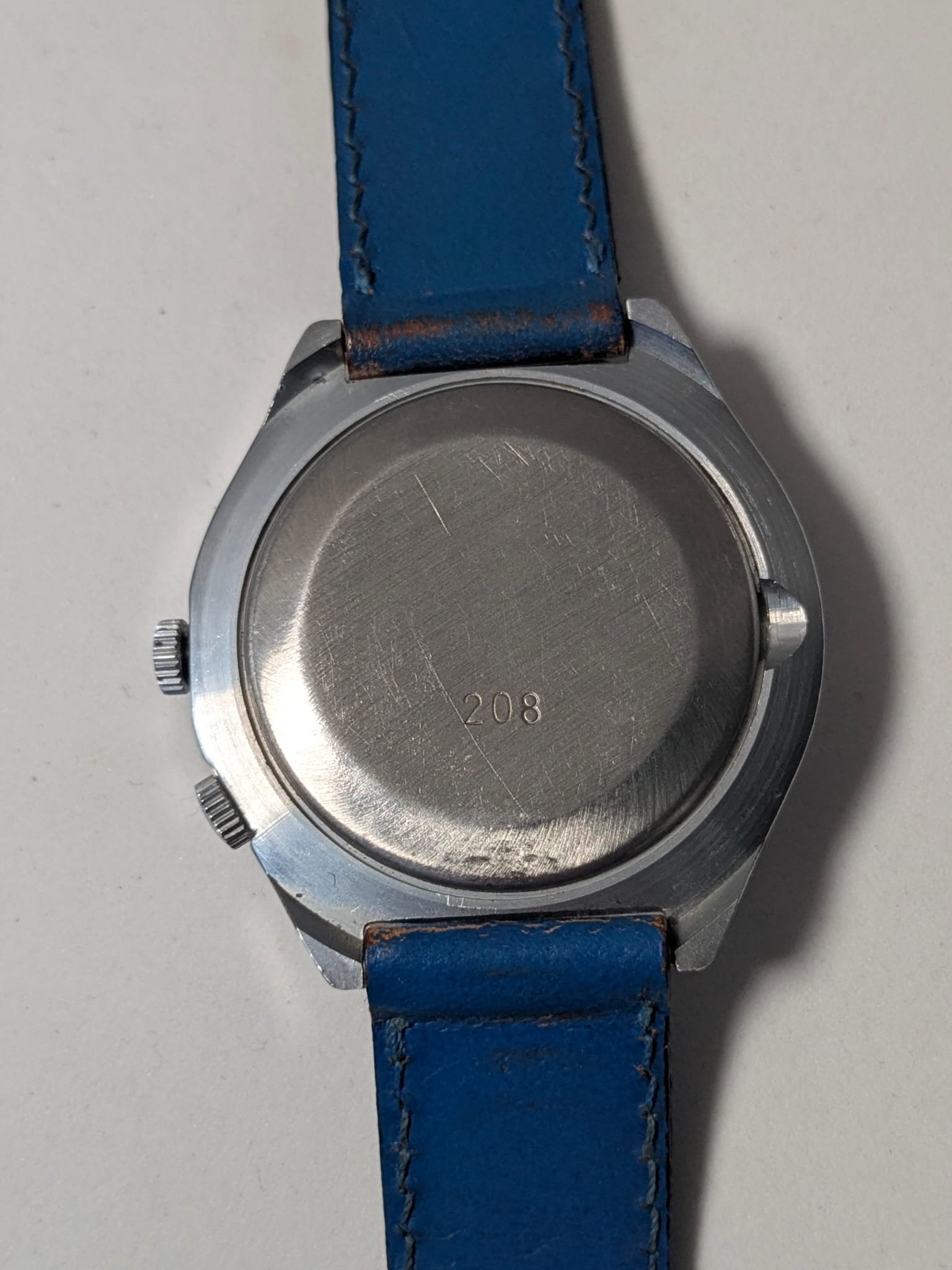 Orologio Sovietico Raketa Marine 24h con Cinturino Originale Blu - Grade B 8 Orologio sovietico Raketa Marine 24 ore anni '80 con quadrante argentato, linee blu tratteggiate per silenzio radio e cinturino blu