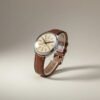 Orologio vintage russo da collezione con distintivo quadrante a parole cirilliche, cassa lucida e cinturino in pelle marrone.