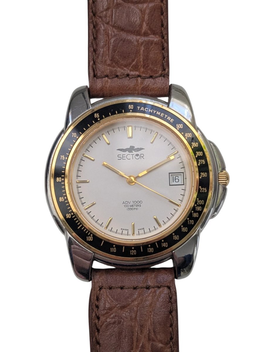 Orologio Sector ADV 1000 Quartz Anni ’90 Tachimetro Swiss Made - Grade B 2 Orologio vintage Sector ADV 1000 Swiss Made con lunetta tachimetrica, quadrante bianco, datario e cinturino in pelle marrone.