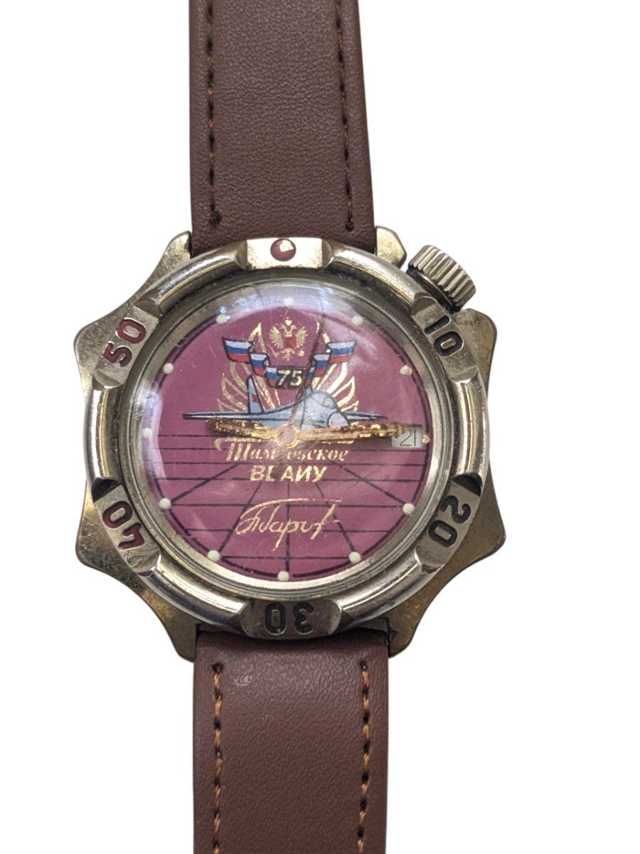 Vostok Komandirskie Scuola superiore di ingegneria aeronautica militare di Tambov – Grade B 2 Orologio russo vintage Vostok Komandirskie. Quadrante bordeaux commemorativo Tambov VL AIU 75°, con jet, aquila e data. Cinturino in pelle.
