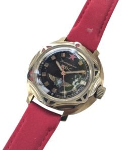 Orologio Vostok Komandirskie VVS russo vintage, referenza 257, quadrante nero con emblema aeronautico, cassa dorata e cinturino rosso.