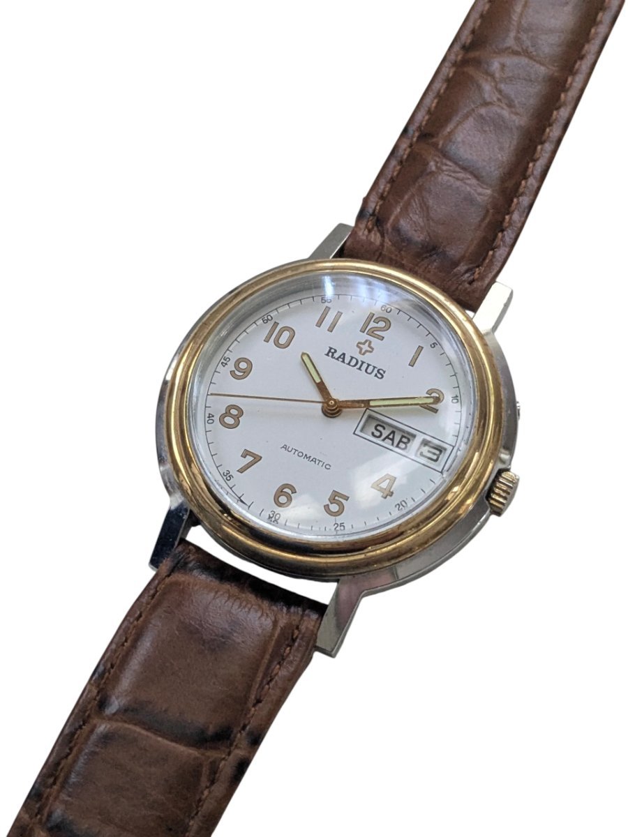 Radius Automatico Vintage Cassa Bicolore Calibro Slava 2427 – Grade B 6 Orologio automatico vintage russo Radius con quadrante crema, numeri arabi dorati, datario SAB 3 e cinturino in pelle marrone.