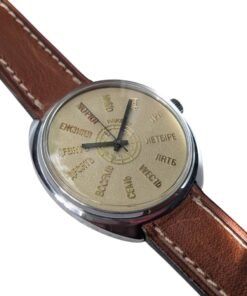 Orologio Raketa vintage russo con quadrante color oro, numeri in cirillico e movimento 2609.HA. Cinturino in pelle marrone; riferimento catalogo 104, vista fronte sinistro.