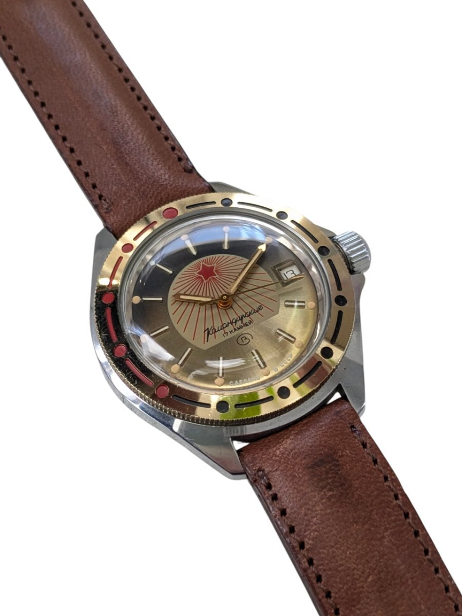 Orologio Vostok Komandirskie Rising Sun Meccanico Manuale URSS - Grade A 10 Orologio vintage Vostok Komandirskie sovietico, ref. 130, quadrante champagne con stella rossa, lunetta bicolore e 17 rubini, cinturino in pelle marrone.