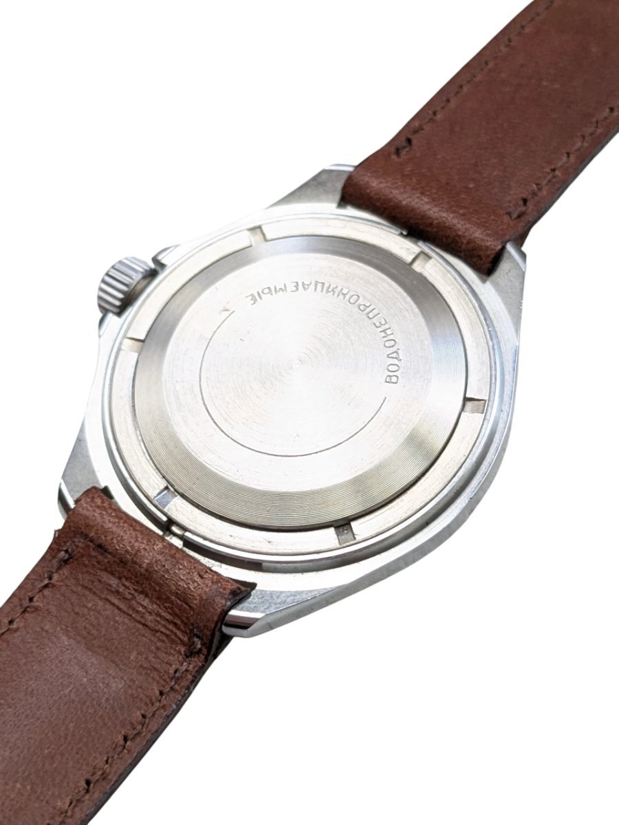 Orologio Vostok Komandirskie Rising Sun Meccanico Manuale URSS - Grade A 7 Orologio russo vintage Vostok Amphibia impermeabile, riferimento catalogo 130. Fondello in acciaio con scritta cirillica e cinturino in pelle marrone. Vista retro destro.