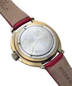 Retro sinistro di orologio russo vintage da collezione, con fondello decorato a raggi e l'incisione "ВОДОНЕПРОНИЦАЕМЫЕ" (Impermeabile) su cinturino in vera pelle rossa.