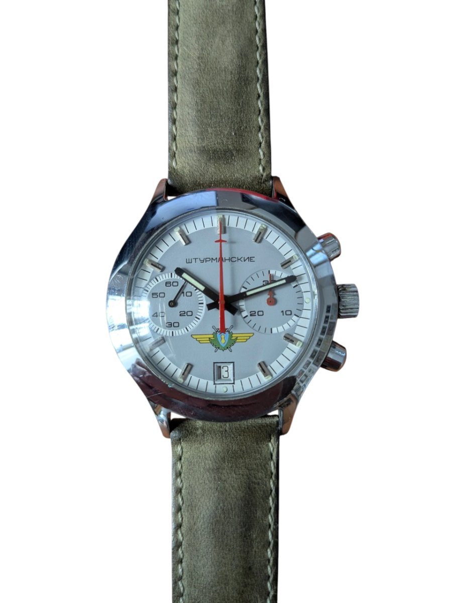 Orologio Sturmanskie Cronografo Calibro 3133 Anni 90 Russia 2 Orologio da collezione Shturmanskie vintage sovietico Poljot cronografo con quadrante argentato, datario e cinturino in pelle verde.