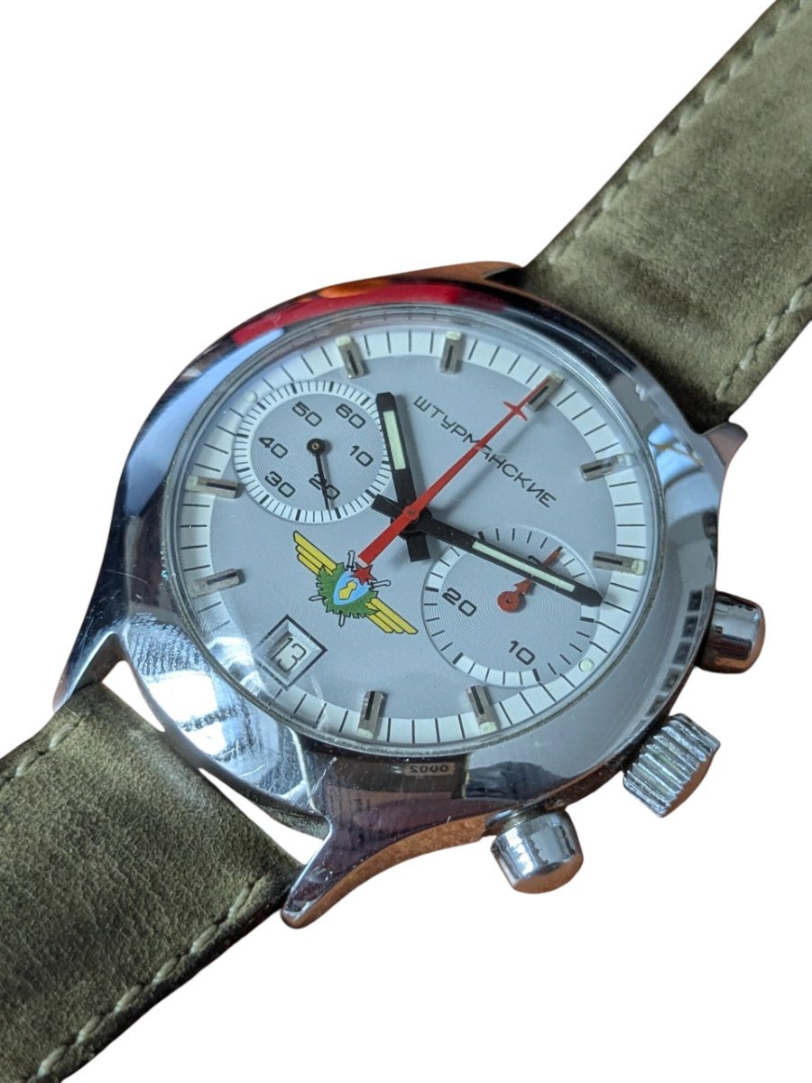 Orologio Sturmanskie Cronografo Calibro 3133 Anni 90 Russia 5 Orologio Sturmanskie vintage sovietico/russo, cronografo con quadrante argentato, logo aviazione, datario e cinturino in pelle.