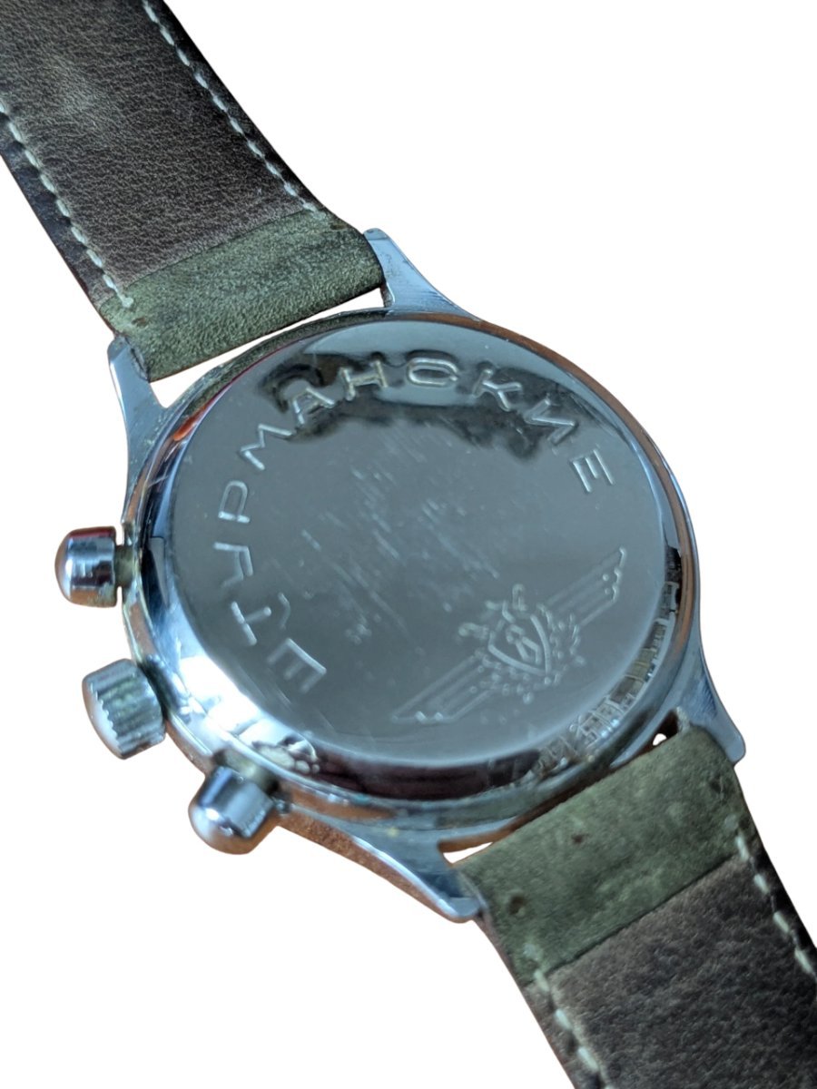Orologio Sturmanskie Cronografo Calibro 3133 Anni 90 Russia 3 Fondello inciso di orologio russo vintage Vostok Komandirskie con scritta cirillica e stemma alato, cinturino in pelle.